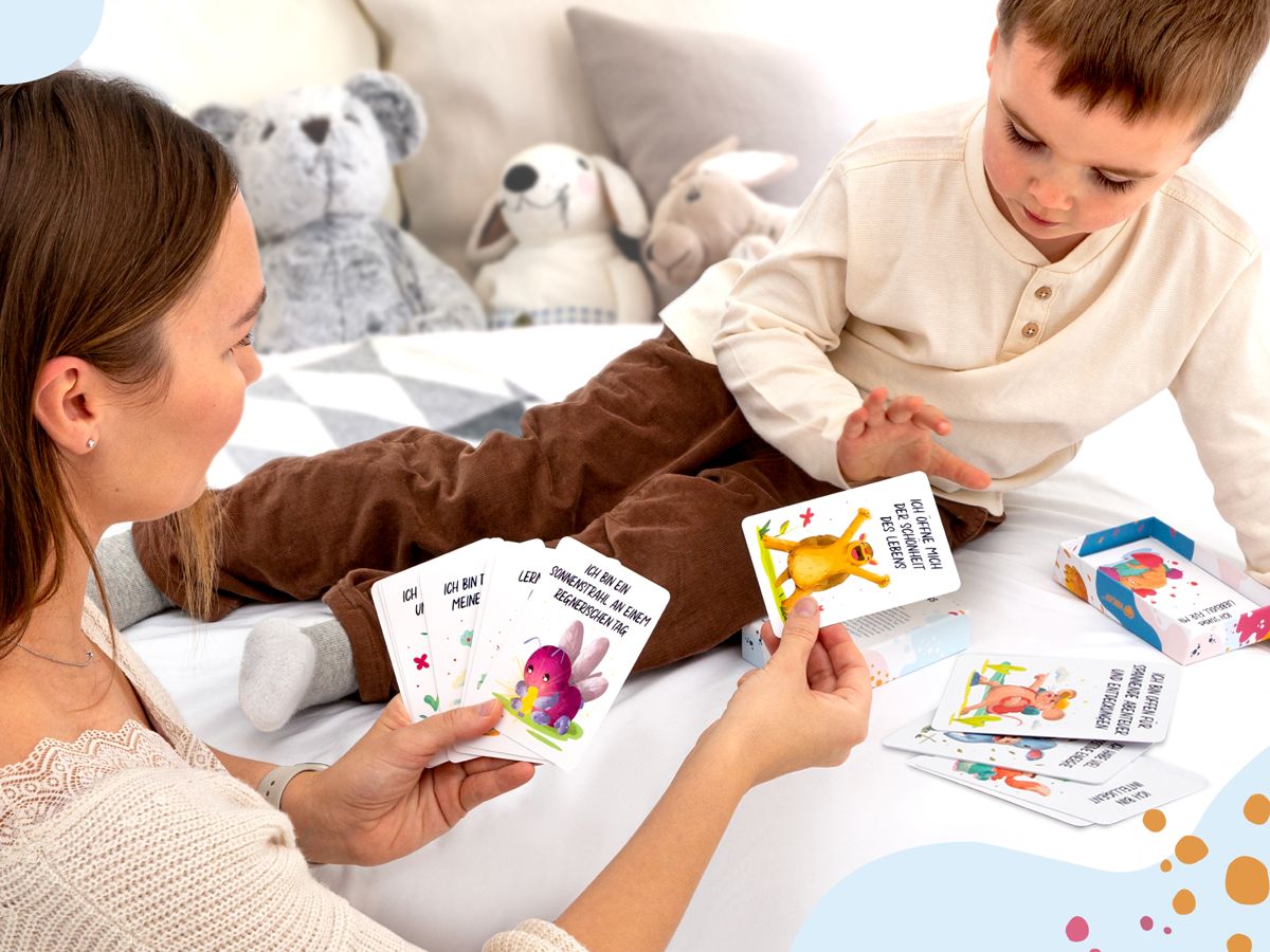 Mutter und Kind spielen mit den Affirmationskarten